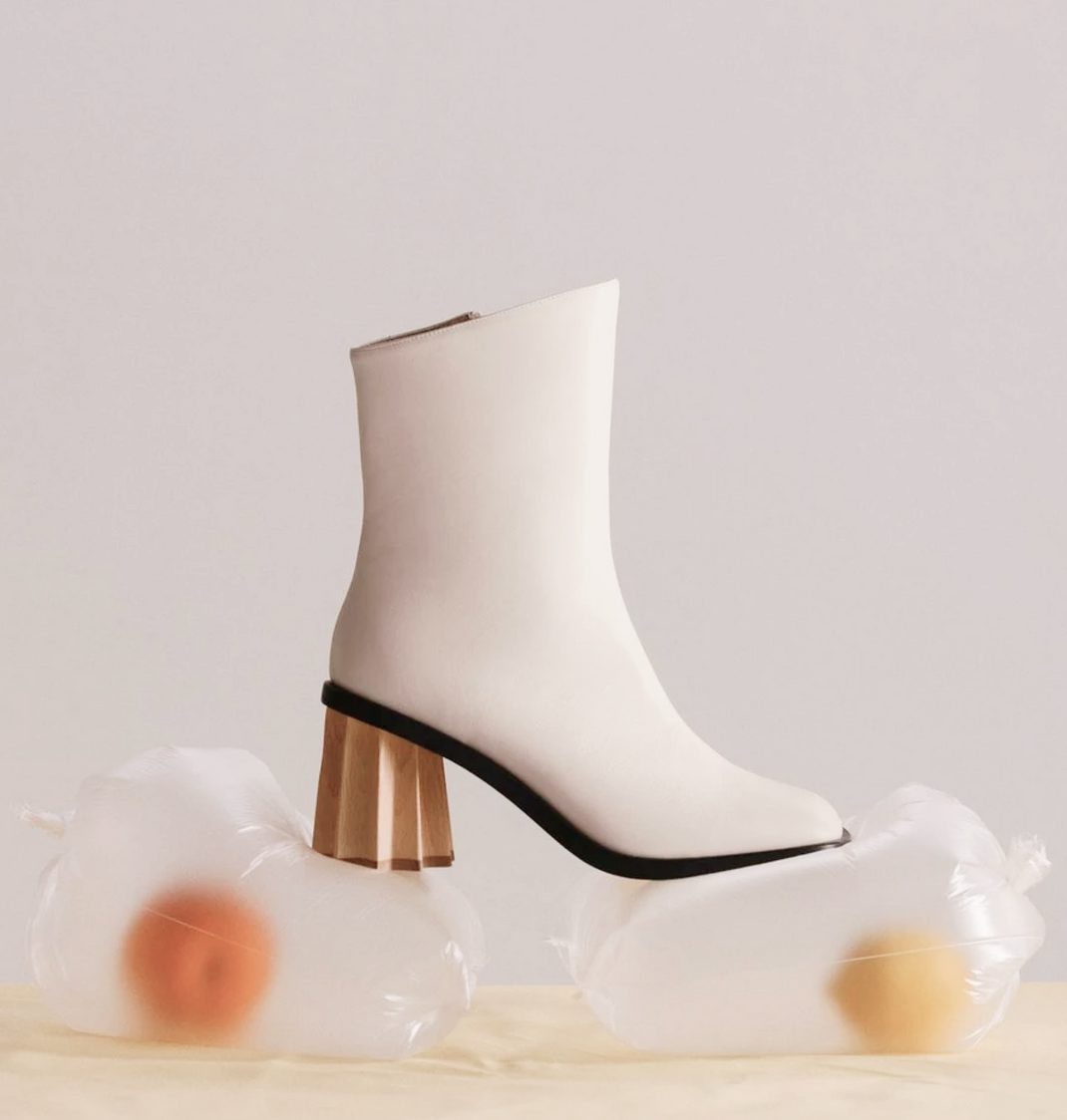 A white boot sits atop two inflated plastic bags. 